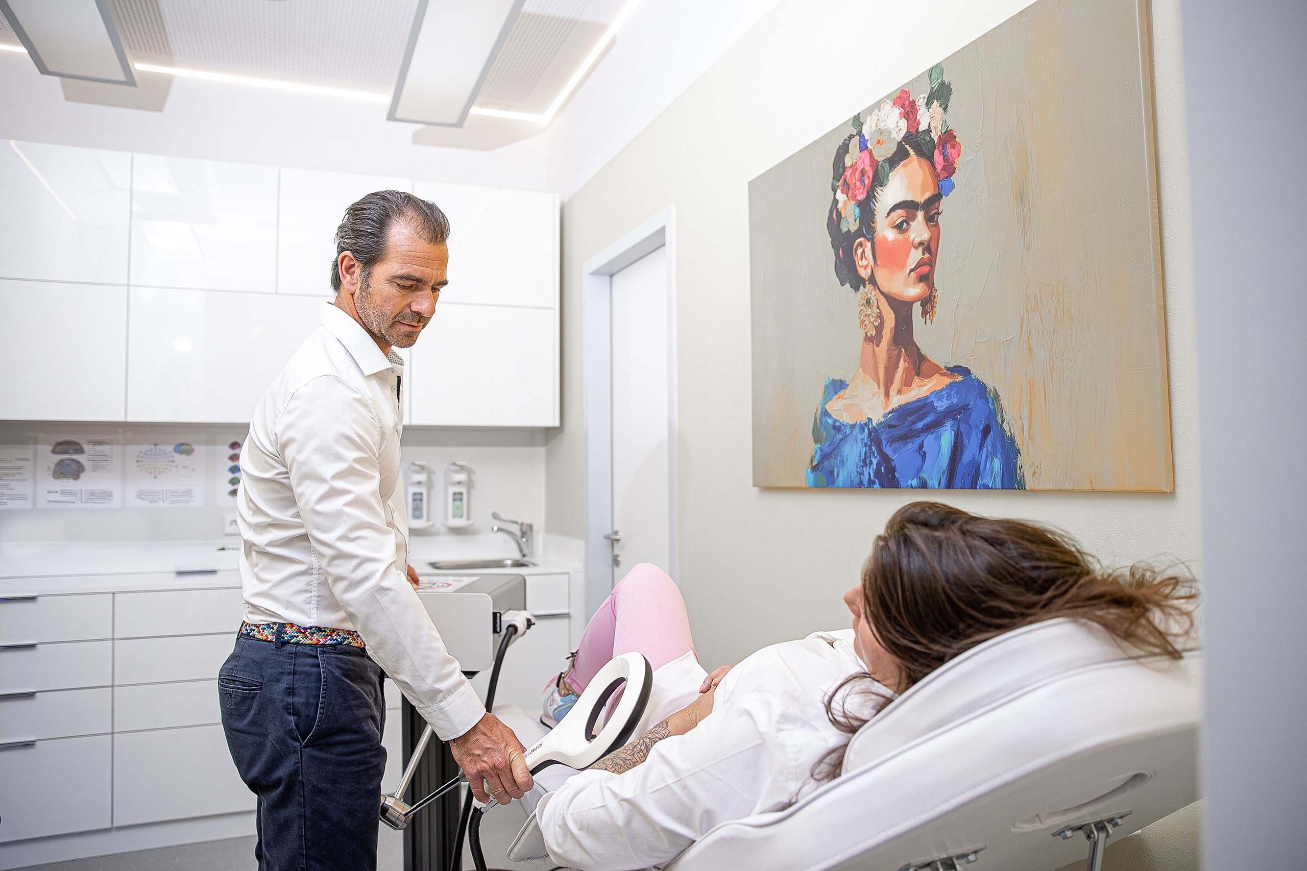 Arzt behandelt Patientin in einer modernen Praxis mit einem medizinischen Gerät